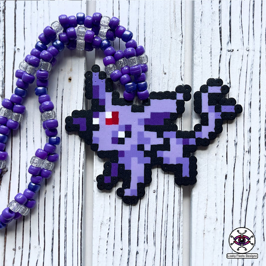 Espion perler necklace. Perler of the pokemon Espion that is cat like with fur colors of lavender and purple. Has a red gem stone on her forehead. Pony beads are purple for the necklace.
