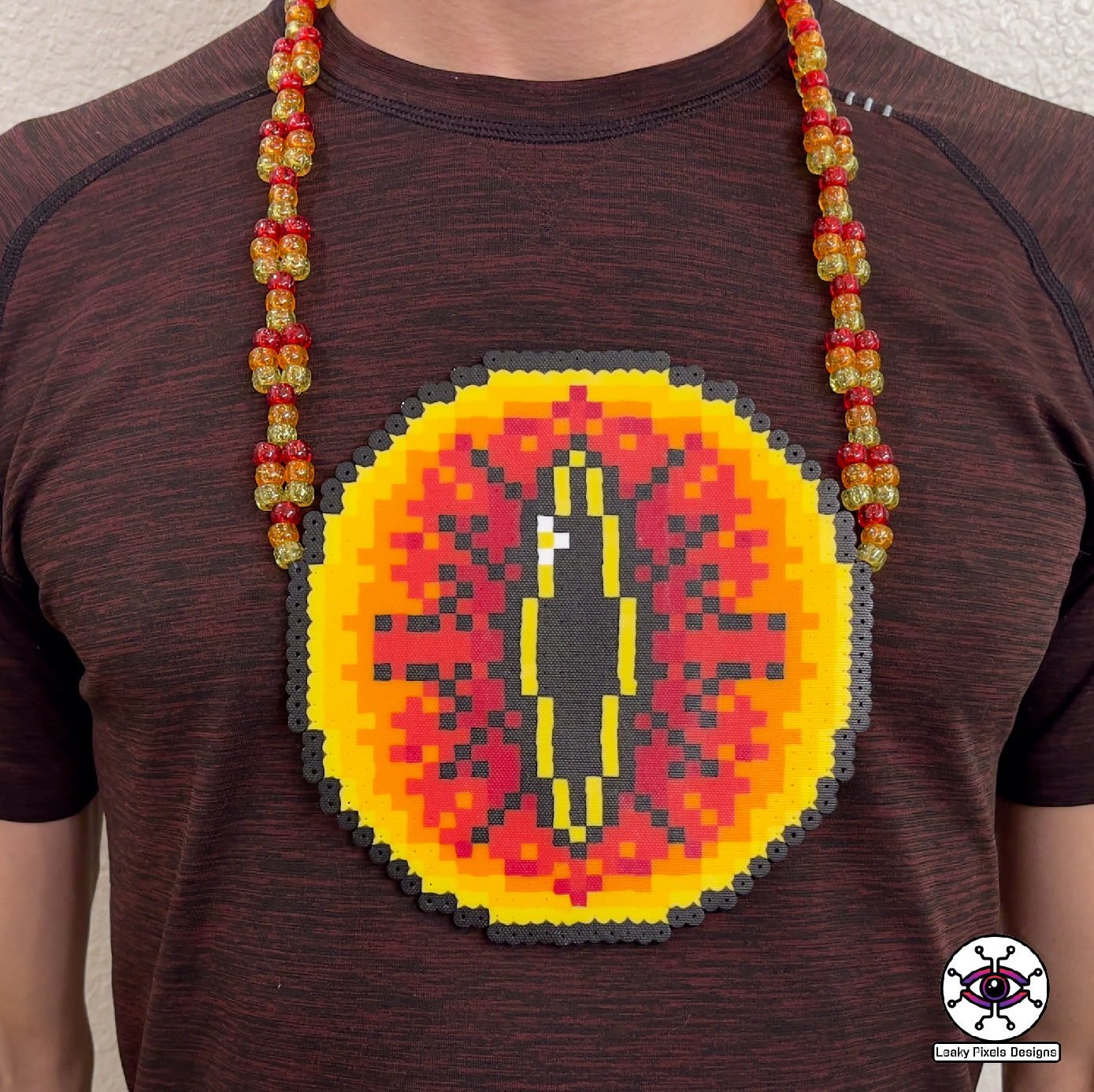 Eye of sauron perler necklace. Large fiery eye with darkness inside it. from Lord of the rings. has red, orange and yellow pony beads as a necklace.