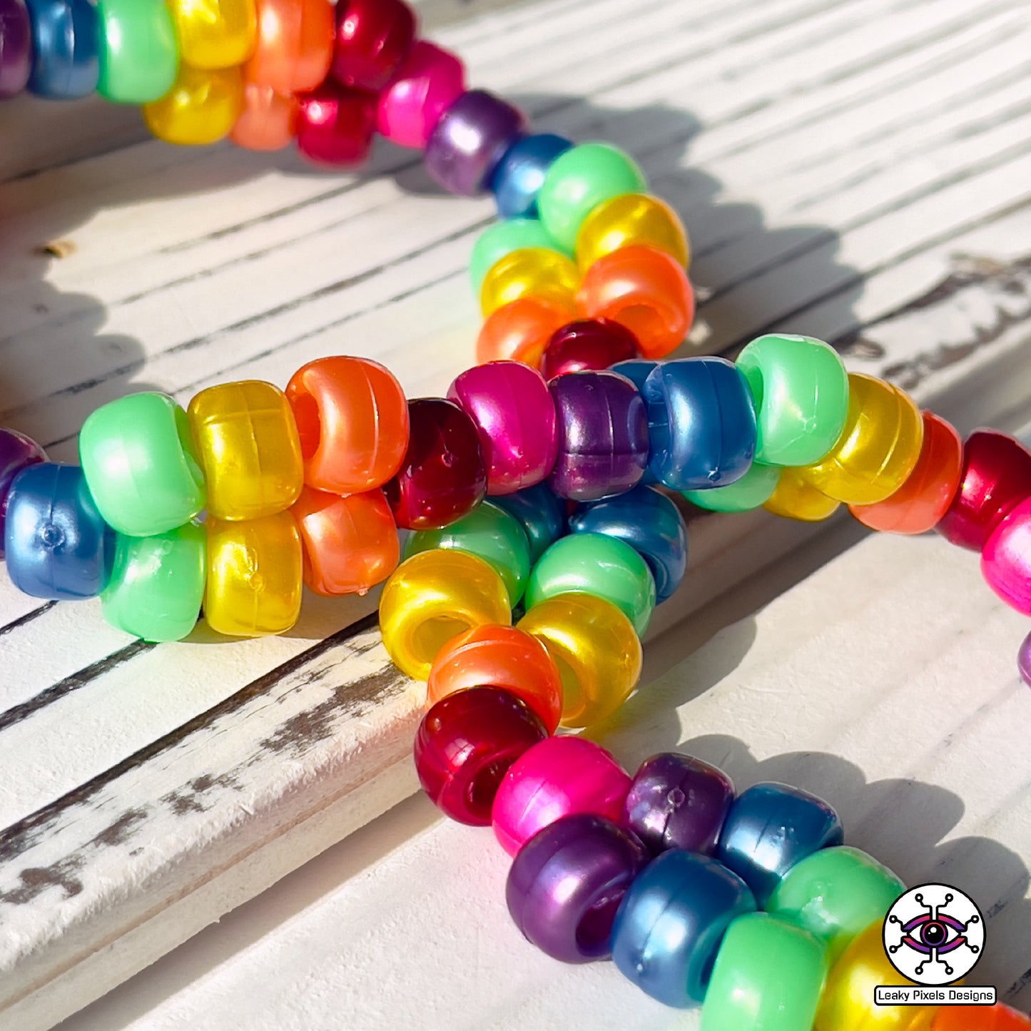 rainbow perler necklace by leaky pixels. red, orange, yellow, green, blue, purple and pink. black storm cloud and pink cloud.