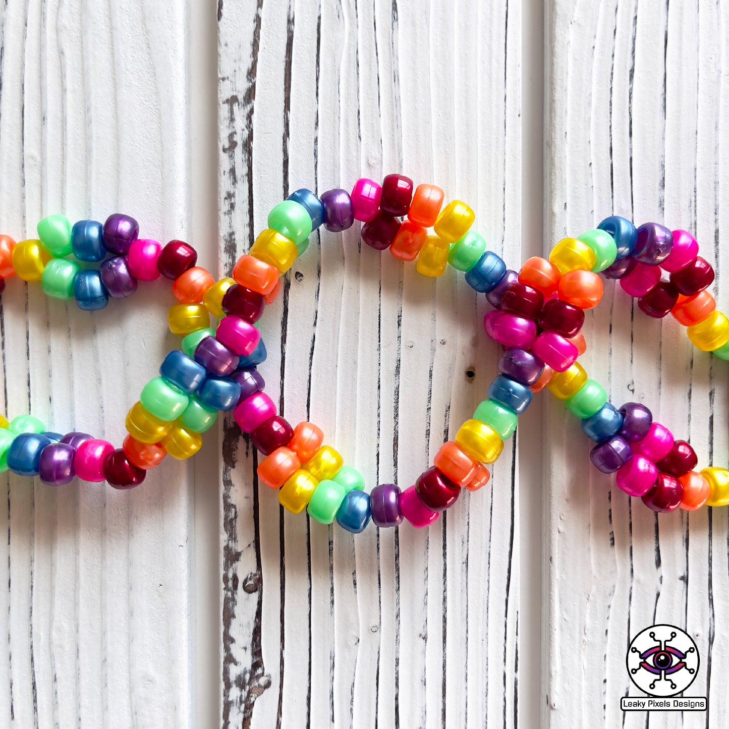 rainbow perler necklace by leaky pixels. red, orange, yellow, green, blue, purple and pink. black storm cloud and pink cloud.