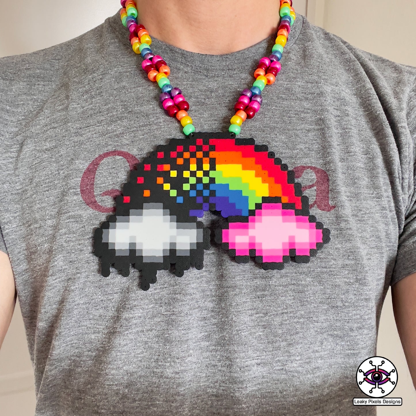 rainbow perler necklace by leaky pixels. red, orange, yellow, green, blue, purple and pink. black storm cloud and pink cloud.