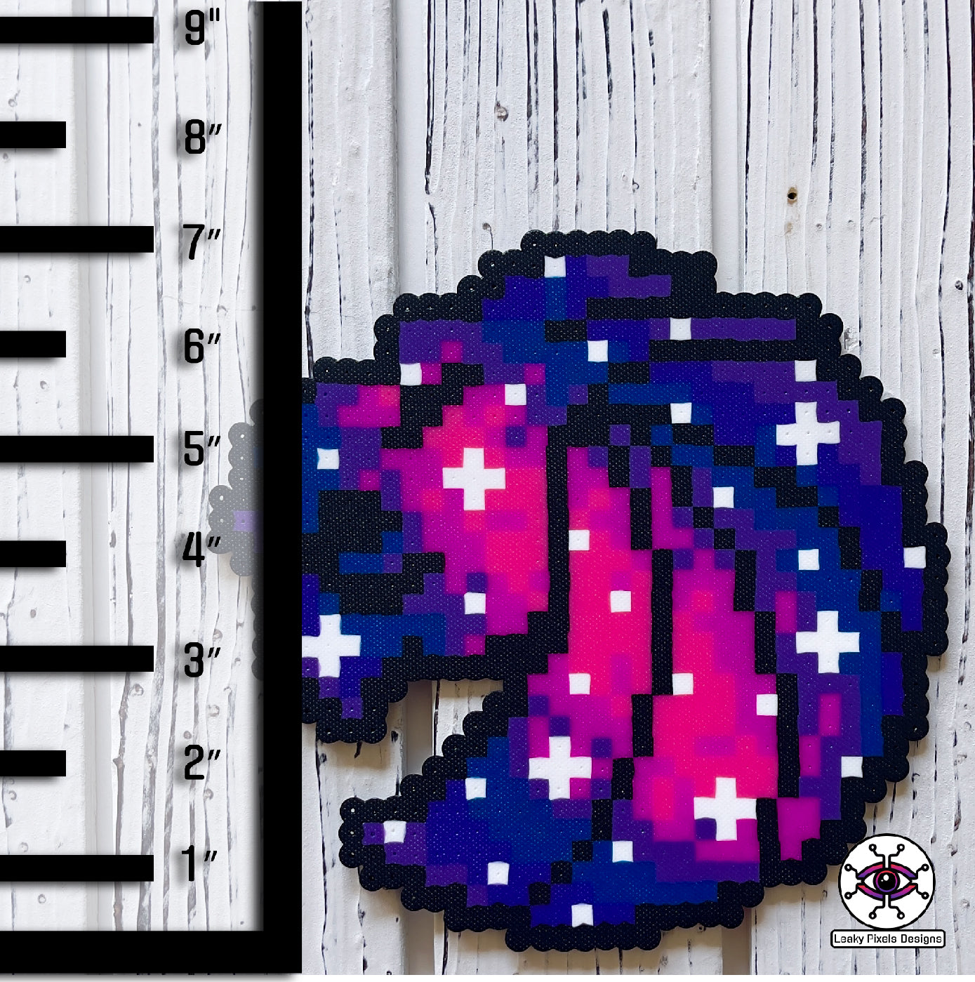 Seven Lions galaxy perler necklace. seven lions logo made of purple, pink, teal, blue and white starts. image of a galaxy. necklace is made of purple, blue, and pink pearl pony beads.