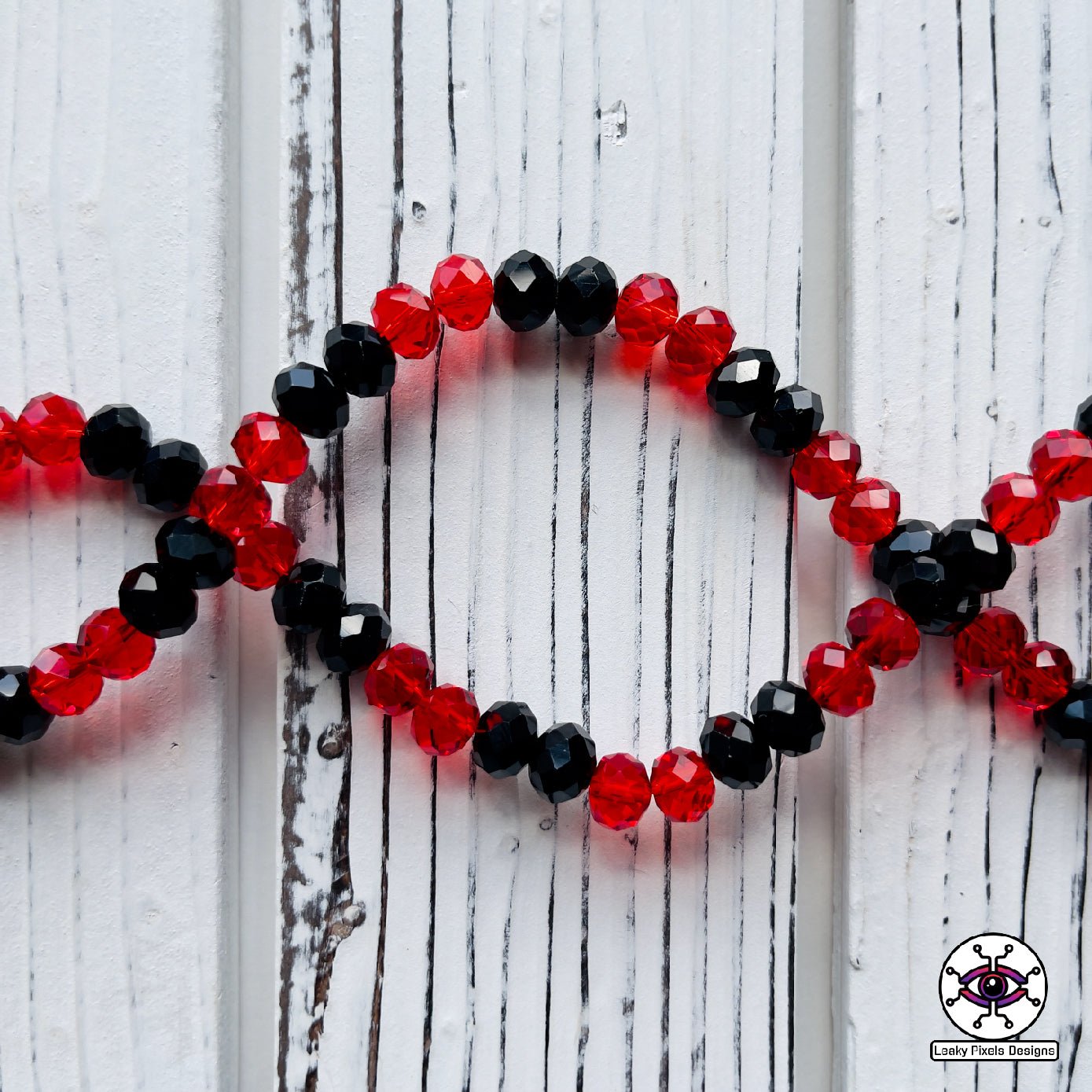Sullivan king perler necklace by leaky pixels. red and black letters with red and black glass crystal beads