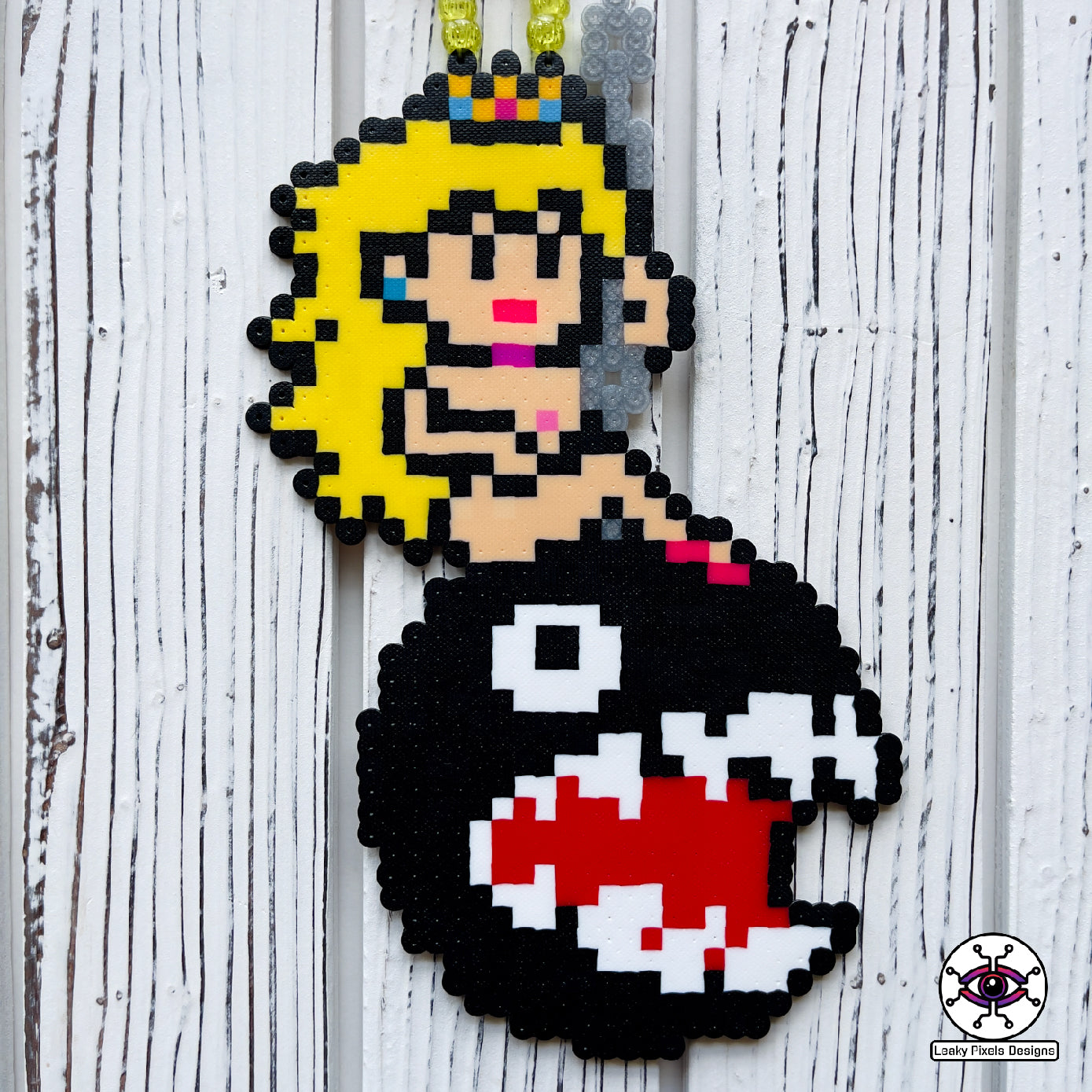 Princess peach perler necklace made by leaky pixels. princess peach nude swinging on a wrecking ball chain chomp from super mario bros.
