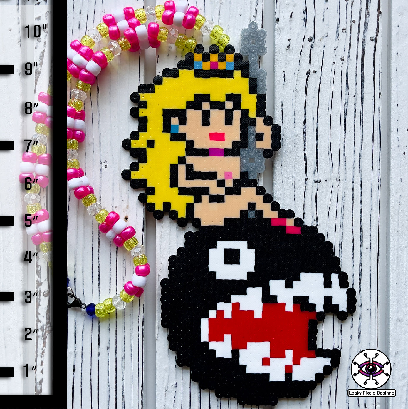 Princess peach perler necklace made by leaky pixels. princess peach nude swinging on a wrecking ball chain chomp from super mario bros.