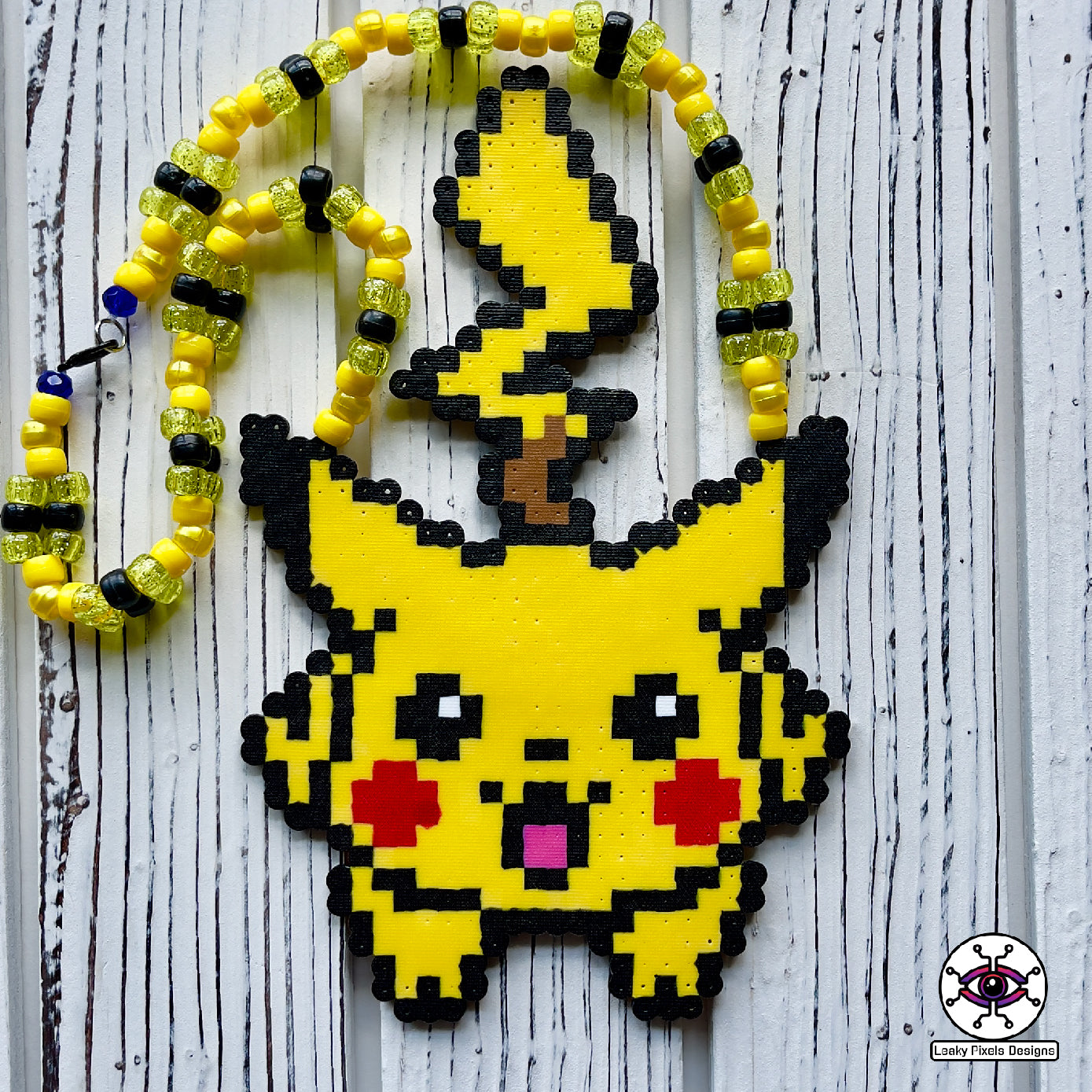 pokemon pikachu yellow perler necklace. Necklace is made of yellow glitter yellow pearl, yellow and black pony beads with a clasp. Pikachu is running with a smile.