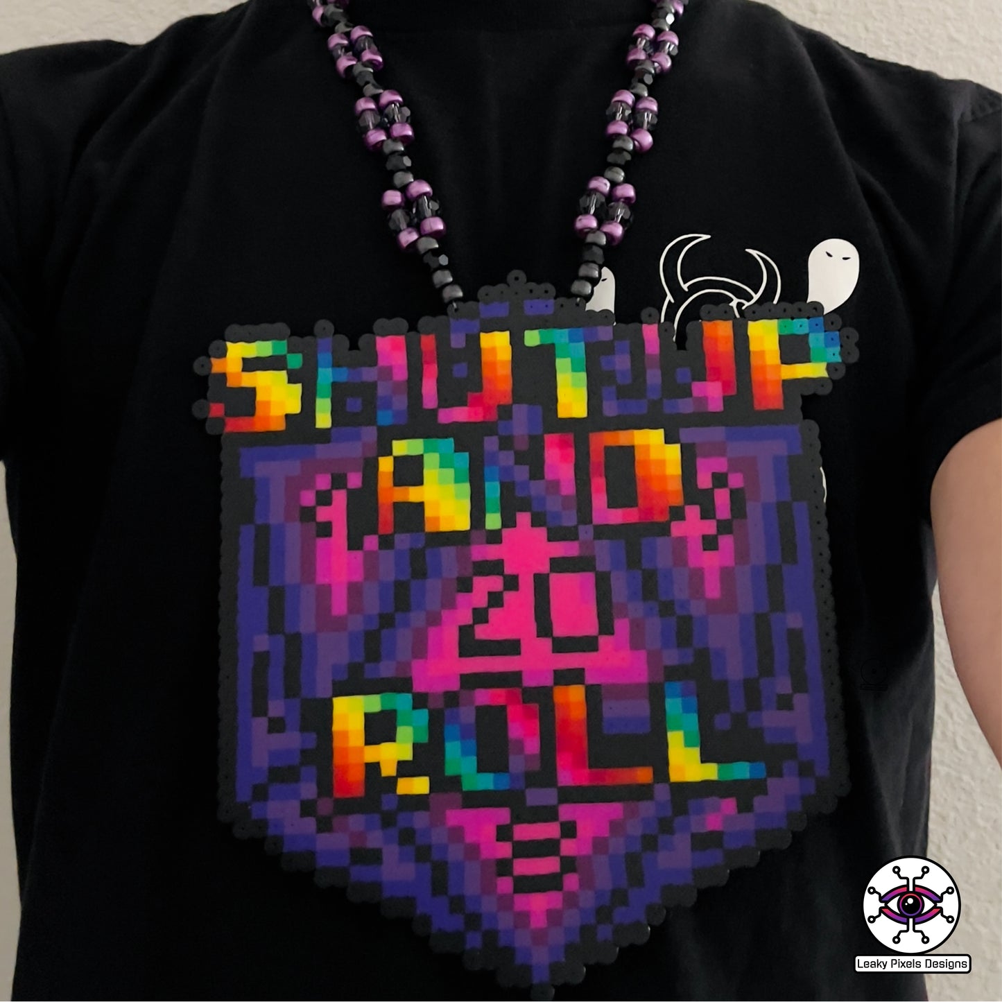 baldurs gate dungeons and dragons d20 dice perler necklace by leaky pixels. says shut up and roll on the front in rainbow letters