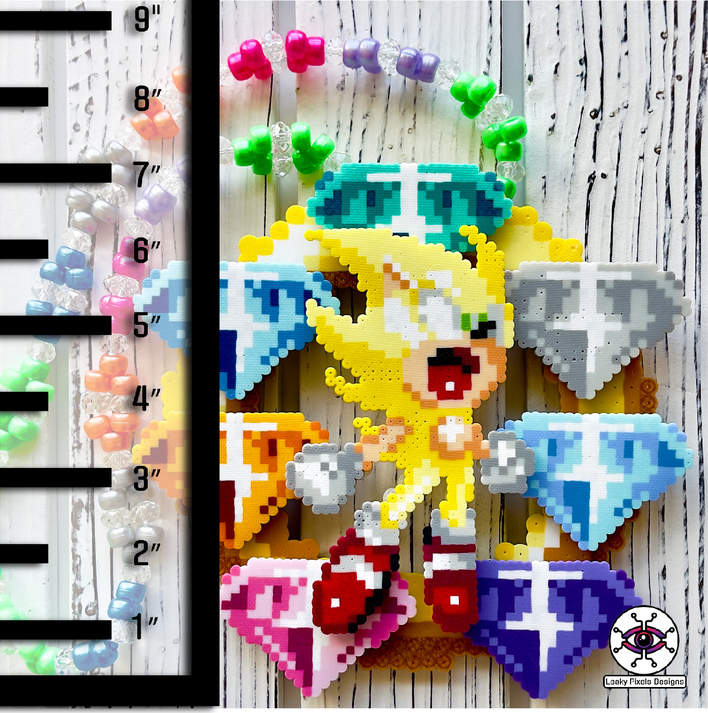 hyper sonic perler necklace by leaky pixels. yellow hyper sonic with stars around him, placed over 7 super emeralds green, blue, light blue, white, pink, orange and purple, on top of a gold ring. necklace is made of same colors of gems.