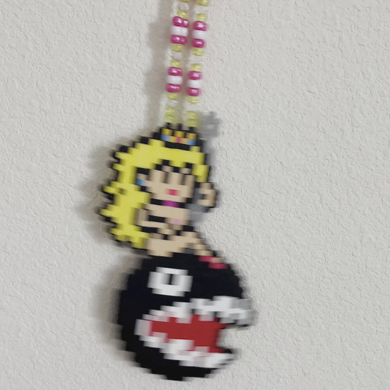 Princess peach perler necklace made by leaky pixels. princess peach nude swinging on a wrecking ball chain chomp from super mario bros.